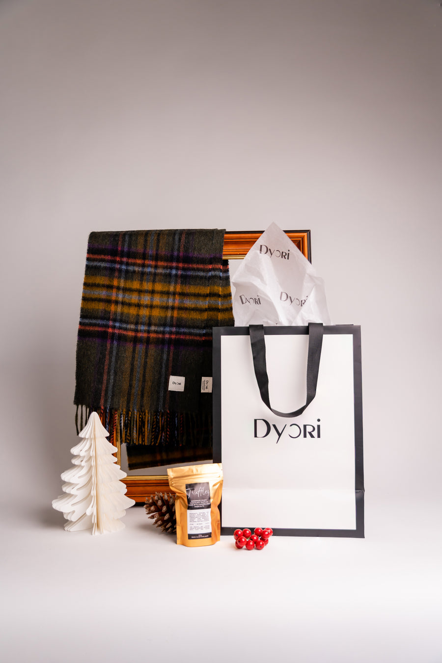 Olive Green Tartan scarf with orange, yellow, and purple stripes, featuring a soft brushed texture and fringed edges and Hazelnut Chocolate truffles