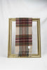 A beautifully designed beige tartan wool scarf featuring red, blue, and yellow checkered patterns is elegantly draped over a gold frame against a white background. The soft texture and timeless plaid design make it a perfect winter accessory and a thoughtful gift for her. Available with fast delivery across Malta.