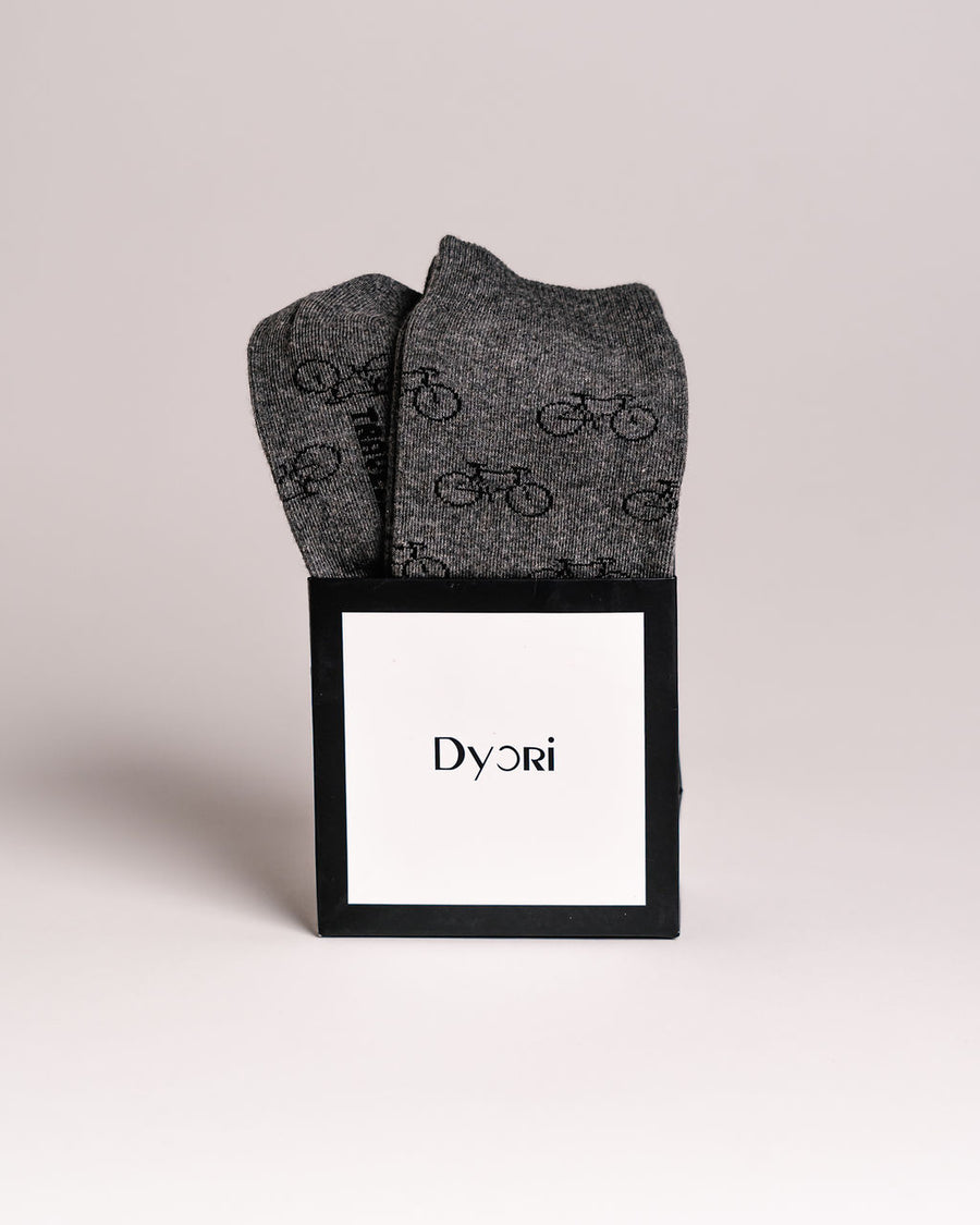 Gray socks with bicycle pattern in a black Dyori box on a light gray background. Secret Santa Gifts Malta