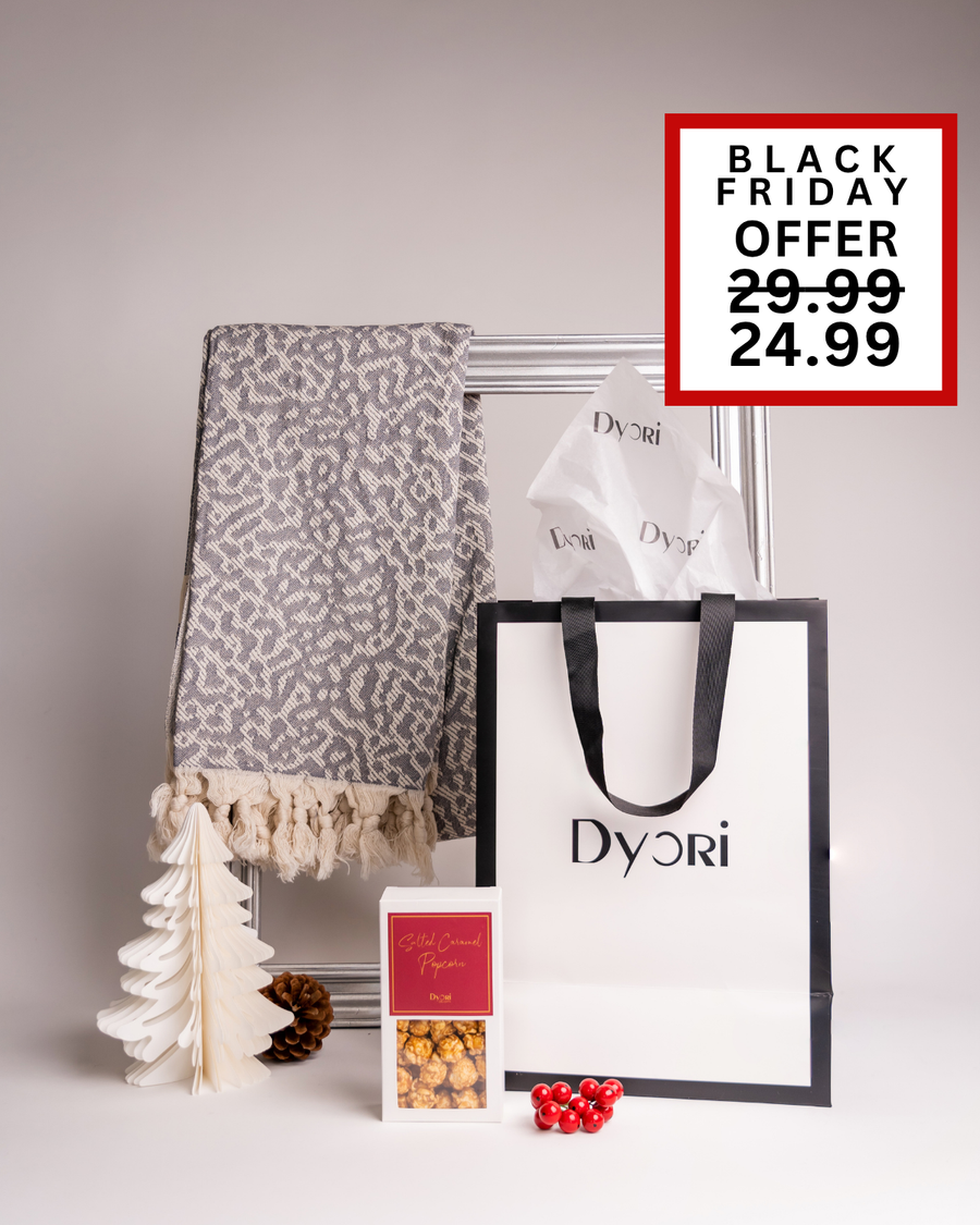Elegant grey patterned throw blanket paired with salted caramel popcorn and a Dyori gift bag. A sophisticated and cozy Black Friday Christmas gift available across Malta for friends, family, or business gifting.