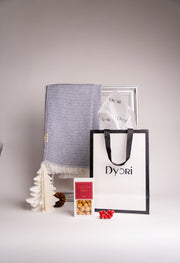 Luxurious blue cotton and bamboo scarf displayed with Dyori gift bag and holiday treats — a thoughtful, sustainable Christmas gift in Malta