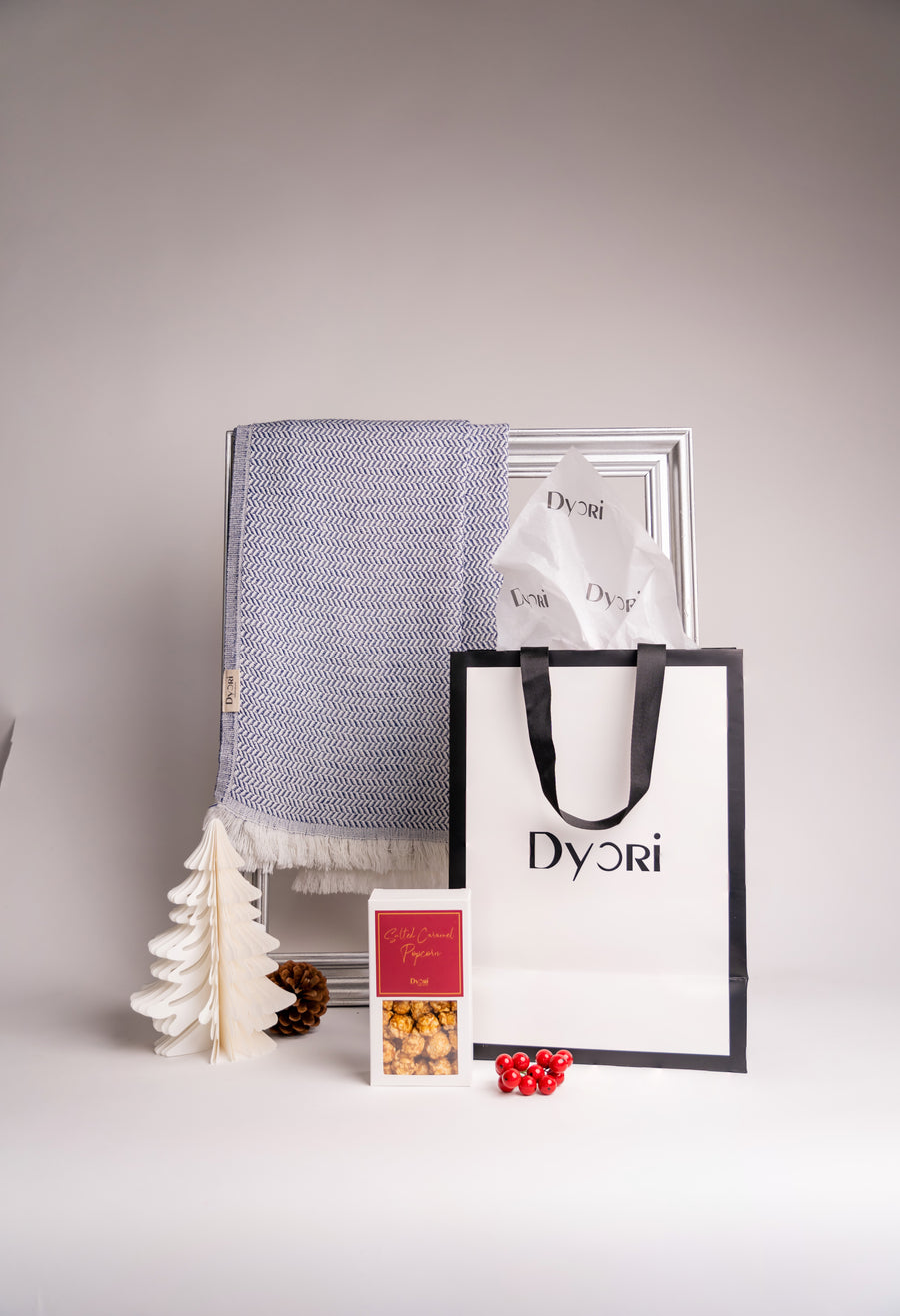 Luxurious blue cotton and bamboo scarf displayed with Dyori gift bag and holiday treats — a thoughtful, sustainable Christmas gift in Malta