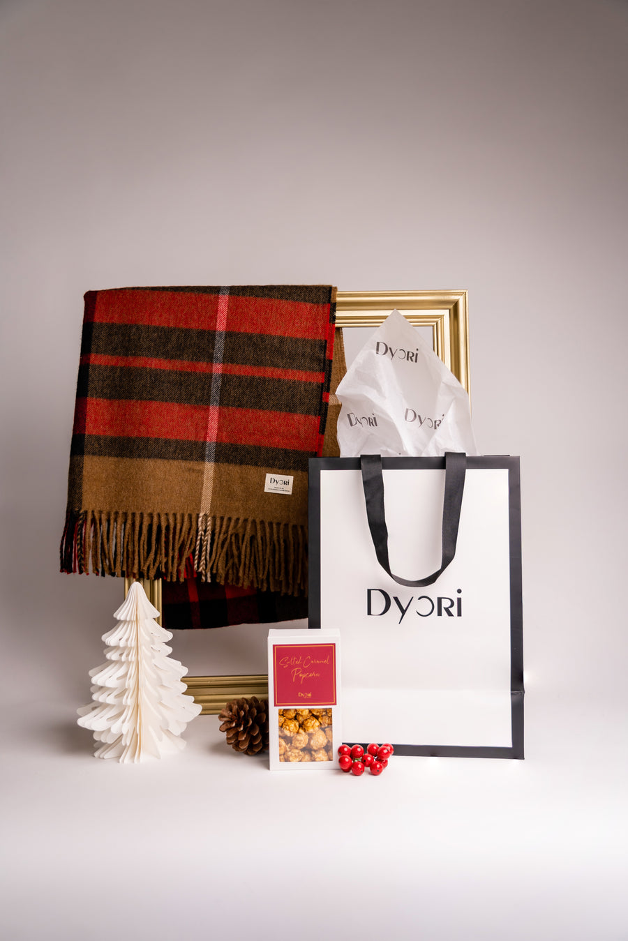 Dyori’s warm brown and red plaid wool scarf styled with seasonal decor, making it an ideal Christmas gift to stay cozy in style.