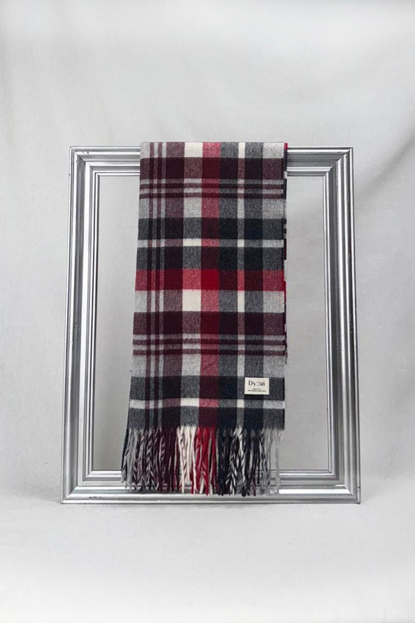 A soft tartan scarf in festive red, grey, and black tones styled elegantly on a silver frame. Ideal for Christmas gifting, this warm wool accessory adds a timeless touch to any winter outfit and makes a thoughtful holiday present.