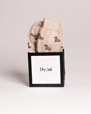 Folded fabric with dog pattern in a black box labeled 'Dyori' on a light gray background. Corporate gifts Malta