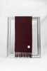 Luxurious solid burgundy merino wool scarf neatly folded to display its fine texture and fringe details. A cozy and stylish gift for him or her, available in Malta.