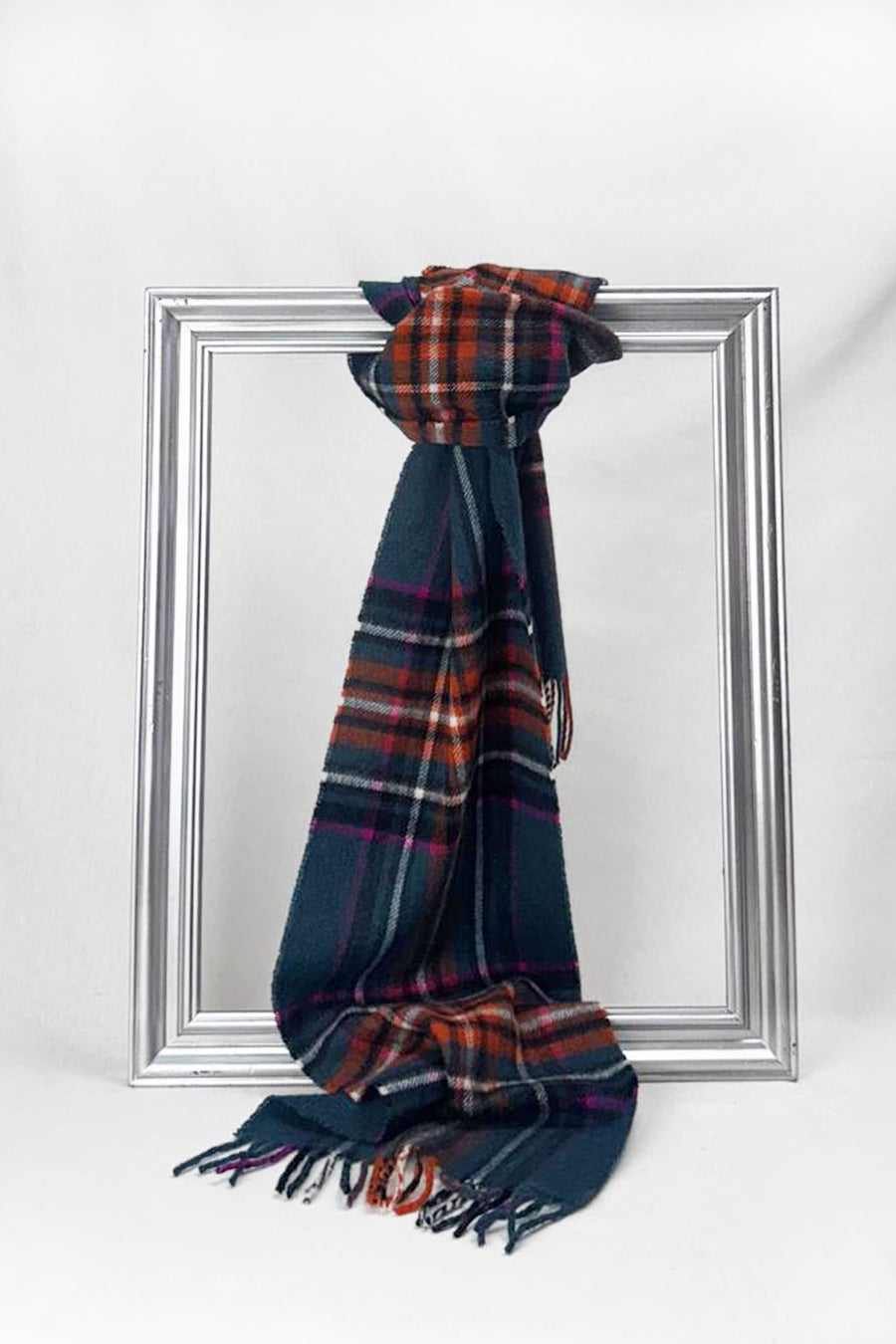 Premium merino wool scarf featuring a bold teal base with rust and magenta check design and soft fringe edges. A warm and elegant unisex gift for him or her. Available in Malta.