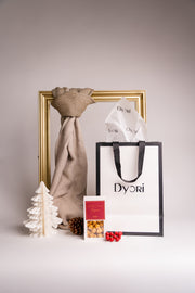 A luxury beige cotton scarf beautifully presented with festive packaging, ideal for eco-friendly Christmas gifts in Malta.