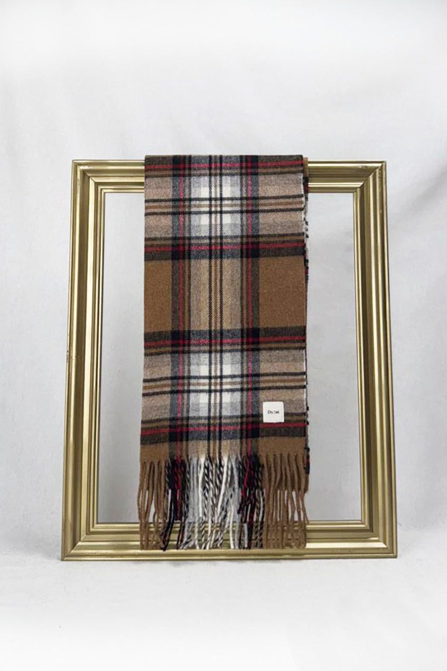 A beautifully folded brown, beige, and red checkered scarf displayed on a gold frame. Crafted for warmth and style, it’s the perfect Christmas or end-of-year gift for teachers. Comes nicely packed and delivered anywhere in Malta.