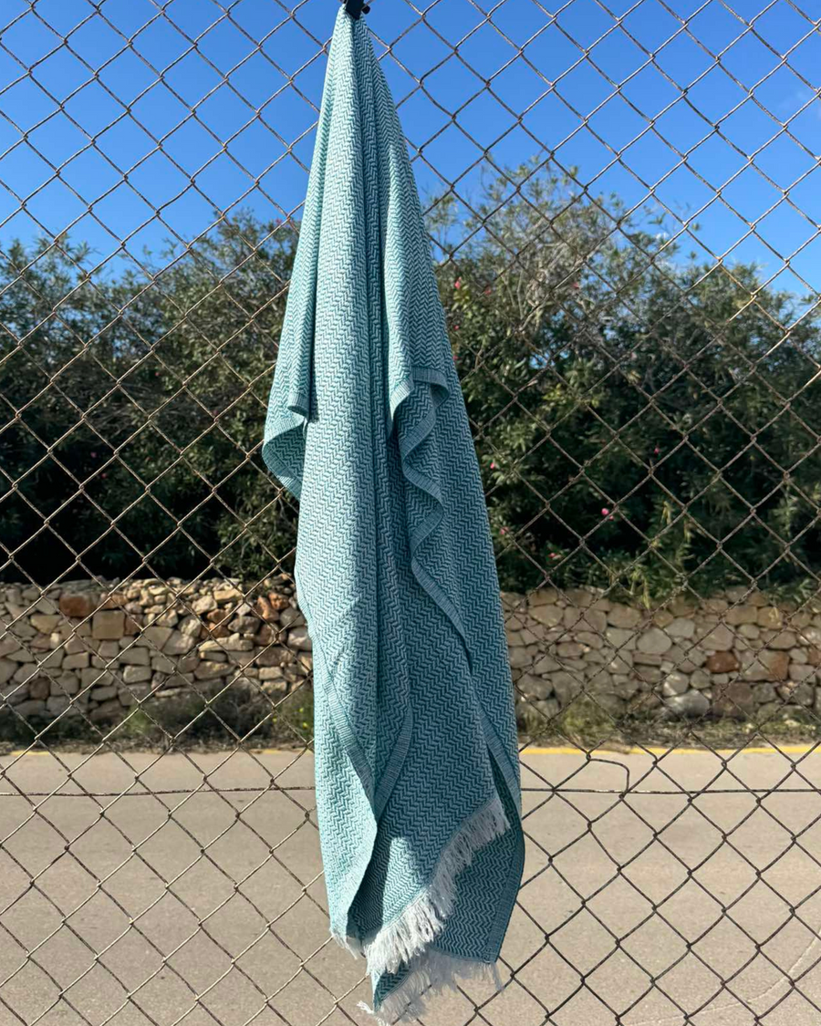 Dyori Frosted Teal Bamboo and Cotton Shawl – Soft turquoise and white Turkish shawl with an elegant herringbone weave and fringed edges, offering a fresh, coastal-inspired touch of comfort and style