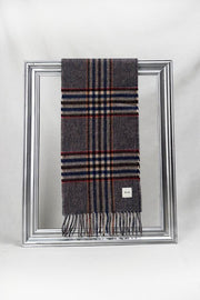 A stylish grey wool scarf featuring a check pattern with navy blue, beige, and red stripes is gracefully looped through a silver frame. Displayed against a clean white background, this soft plaid scarf embodies timeless winter fashion — a warm and elegant gift for her. Available with delivery across Malta.