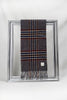 A stylish grey wool scarf featuring a check pattern with navy blue, beige, and red stripes is gracefully looped through a silver frame. Displayed against a clean white background, this soft plaid scarf embodies timeless winter fashion — a warm and elegant gift for her. Available with delivery across Malta.