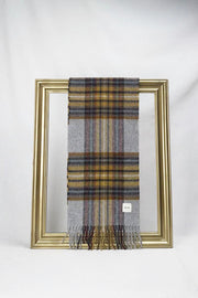 A luxurious grey tartan wool scarf featuring mustard, burgundy, and soft lavender stripes is gracefully looped through a gold picture frame. The rich plaid texture and soft fabric create a refined winter look, making it a stylish and thoughtful gift for her. Available with delivery across Malta.
