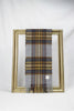 A luxurious grey tartan wool scarf featuring mustard, burgundy, and soft lavender stripes is gracefully looped through a gold picture frame. The rich plaid texture and soft fabric create a refined winter look, making it a stylish and thoughtful gift for her. Available with delivery across Malta.