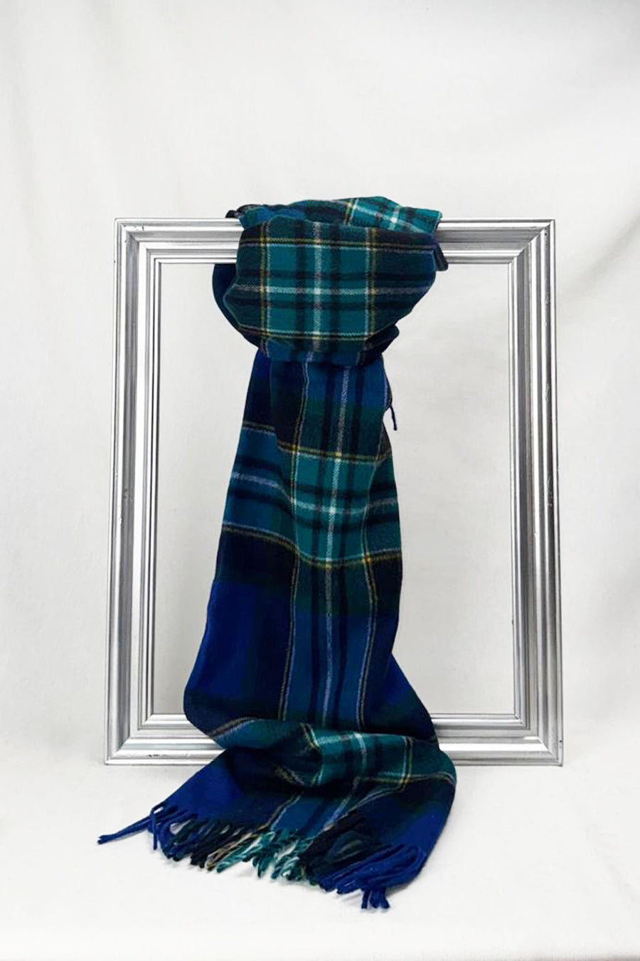 Luxurious merino wool scarf in a classic Highland-inspired blue and green check pattern, elegantly draped over a silver frame. Soft, warm, and stylish — a perfect unisex winter accessory. Delivered in Malta.