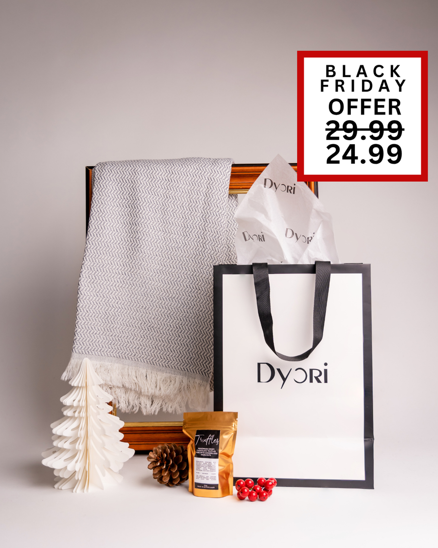 A minimalist Dyori gift set with a light grey herringbone scarf, chocolate truffles, and gift bag. A classy Christmas present for any occasion in Malta.