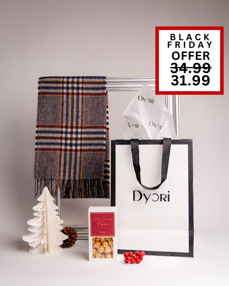 A cozy and classic Dyori Christmas gift featuring a beige and navy check scarf with salted caramel popcorn in festive packaging. Perfect for stylish winter gifting and available for delivery across Malta during Black Friday.