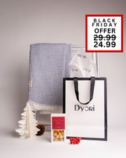 Beautifully presented Dyori Christmas gift with a blue woven throw, salted caramel popcorn, and sleek black-and-white packaging. A stylish and practical luxury gift idea for this Black Friday in Malta.