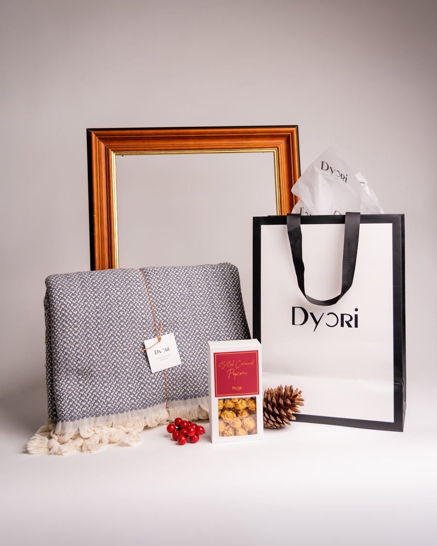 A soft luxury cotton throw beautifully paired with gourmet caramel popcorn, perfect for sustainable Christmas gifts in Malta.