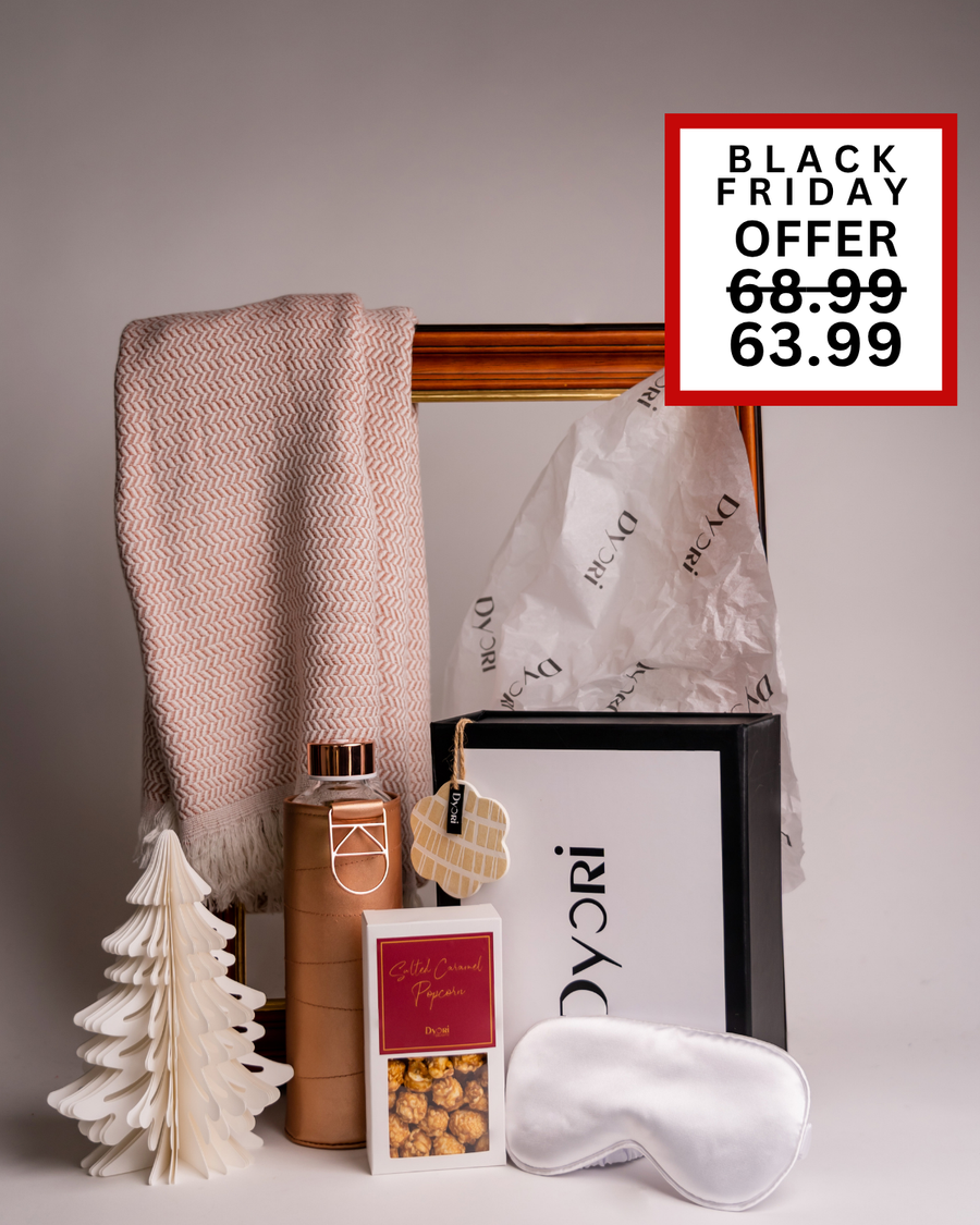 A cozy Dyori Christmas gift box featuring a peach scarf, copper bottle, white eye mask, and popcorn. A pampering and stylish festive gift idea available for Black Friday delivery in Malta.