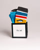 Colorful socks in a black box with Dyori branding on a light gray background Secret santa gifts Malta