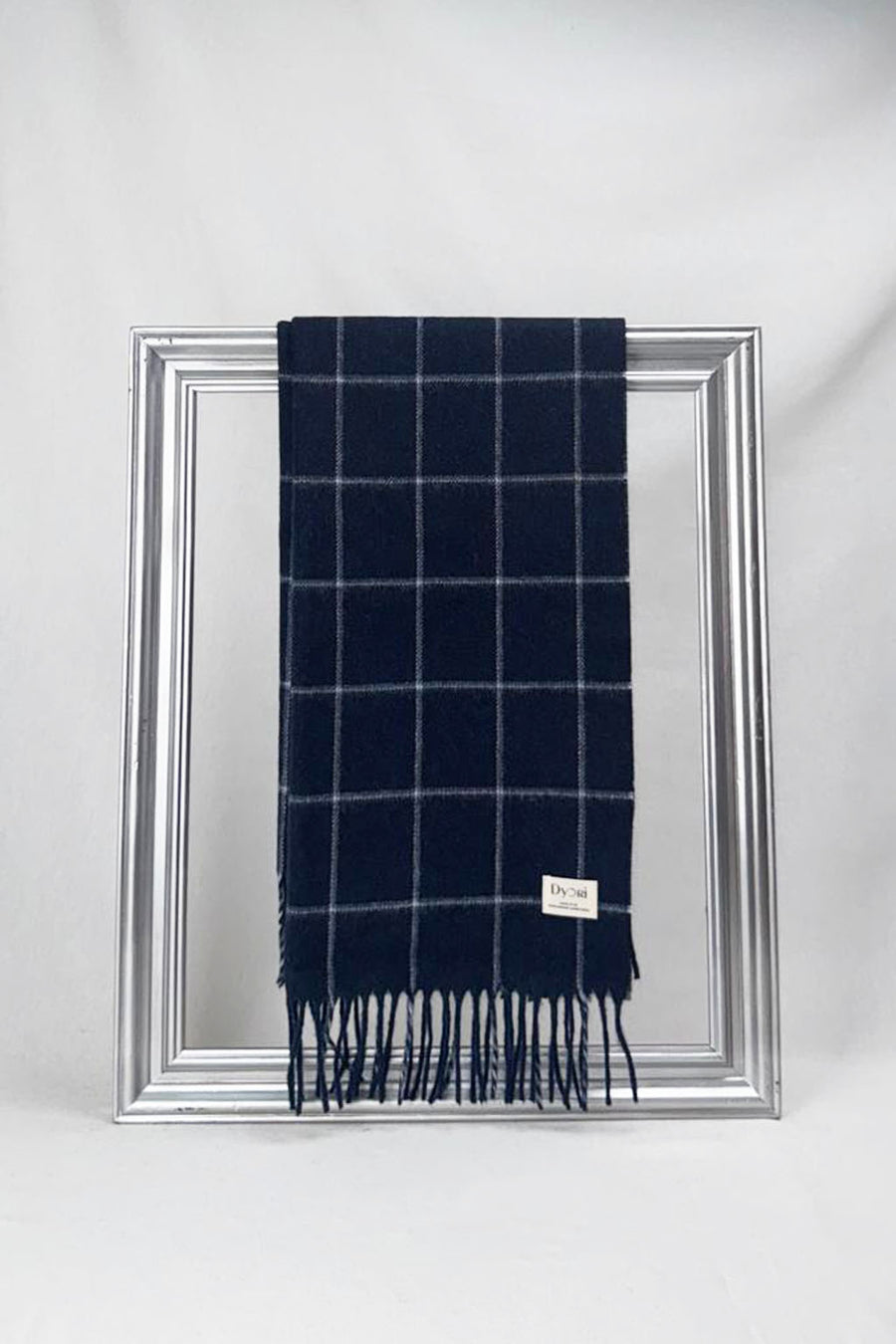 Luxurious merino wool scarf in midnight navy with elegant windowpane checks, beautifully draped on a silver frame. Soft, warm, and timeless — a perfect winter gift for him or for her. Delivered in Malta.