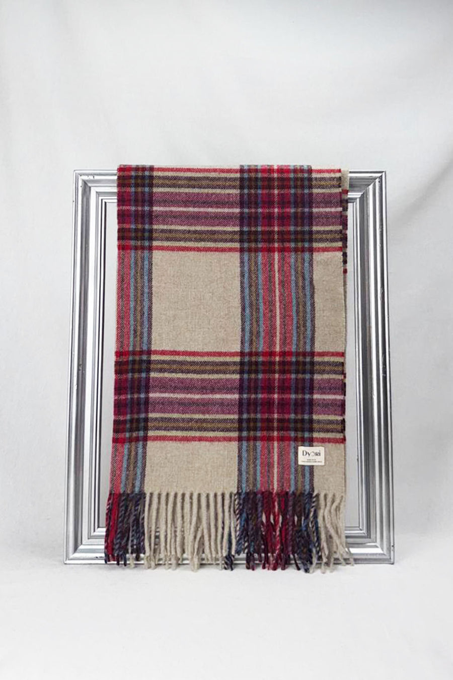 Classic plaid merino wool scarf combining beige, red, and blue tones with fringed edges. Cozy, warm, and ideal as a thoughtful gift for him or her.