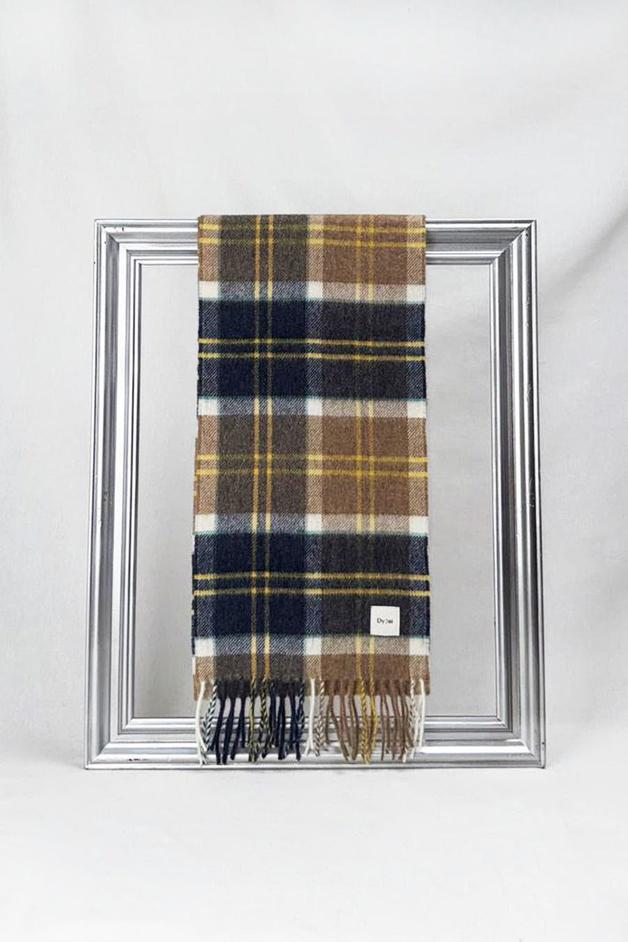 Stylish merino wool scarf in a rich navy, camel, and mustard check pattern, elegantly draped over a silver frame. Luxuriously soft and warm — the perfect unisex gift for him or her. Delivered in Malta.