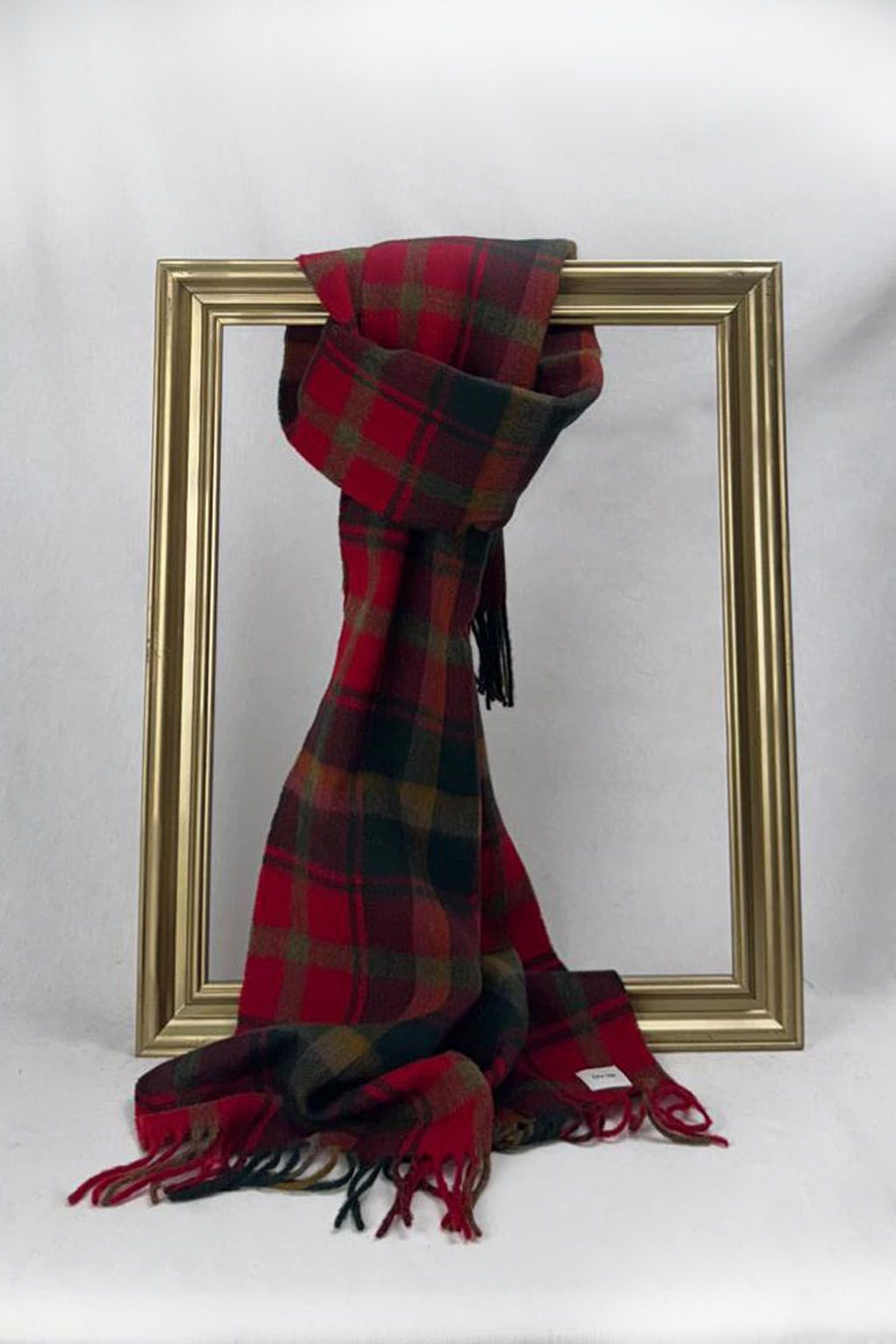 A soft red, green, and brown checkered scarf tied stylishly on a gold frame. This festive plaid scarf makes a heartfelt teacher gift for Christmas, combining timeless charm with warmth and comfort. Delivered beautifully wrapped across Malta.