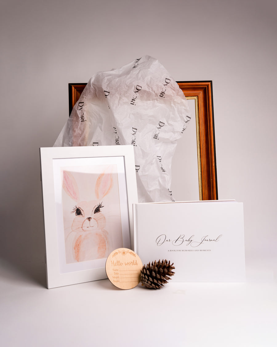 Unique baby keepsake gift by Dyori Malta featuring a luxury baby journal, soft pastel bunny art print, and wooden “Hello World” plaque. Perfect sustainable and locally delivered baby gift for new parents, baby showers, or christenings. Beautifully gift-packed and made with love in Malta.